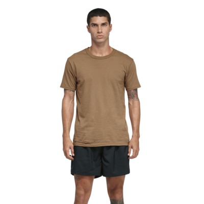 man facing front in a tan shortsleeve tshirt with black shorts