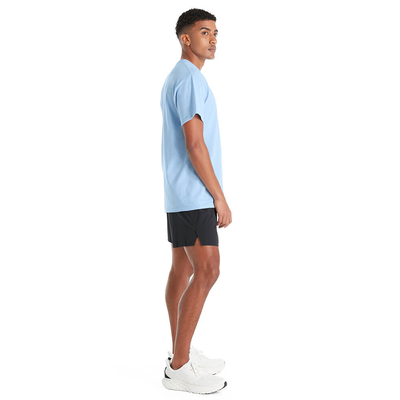 man standing sideways wearing delta apparel style 11750 short sleeve tee shirt in sky blue