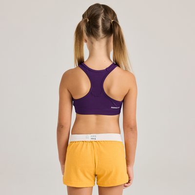 girl facing backward wearing navy top and yellow shorts 1210G