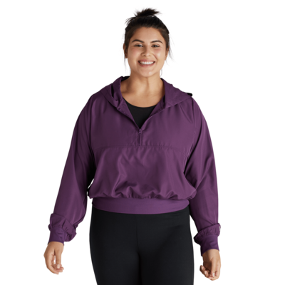 woman facing front wearing a plum quarter zip warm up jacket and black leggings
