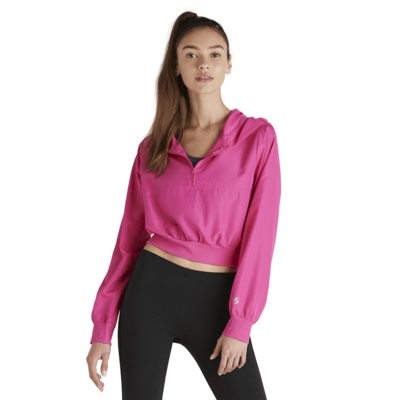 girl facing front wearing a pink quarter zip crop top warm up jacket
