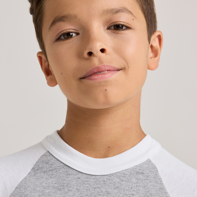 boy facing front wearing a grey and white baseball t shirt and red shorts 210B neckline