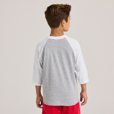 boy facing back wearing a grey and white baseball t shirt and red shorts 210B