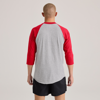 man facing rear wearing a grey and red baseball t shirt and black shorts 210M
