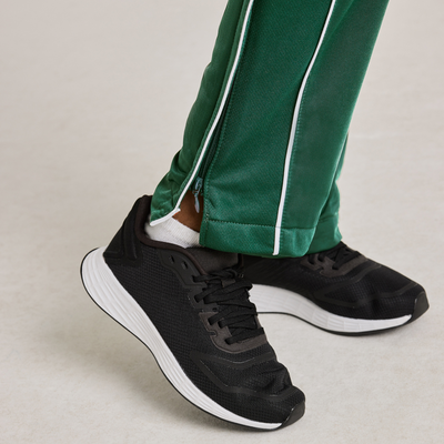 boy wearing green warm up pants with white stripes 3245Y