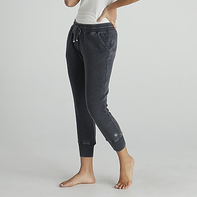 young woman with hands in pockets wearing dark grey jogger sweatpants