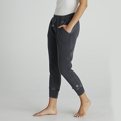 young woman with hands in pockets wearing dark grey jogger sweatpants