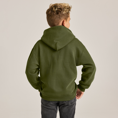boy wearing a green zip up hooodie looking back with one hand in the front pocket B9078