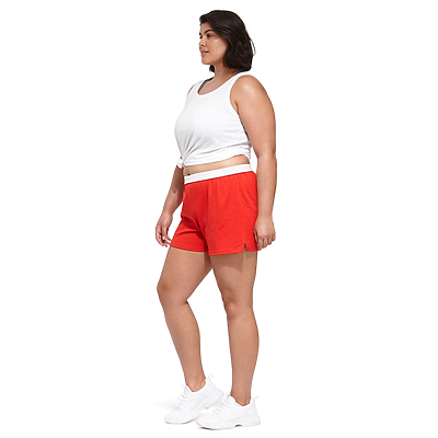 woman facing sideways wearing a knotted white tank top and red authentic soffe shorts