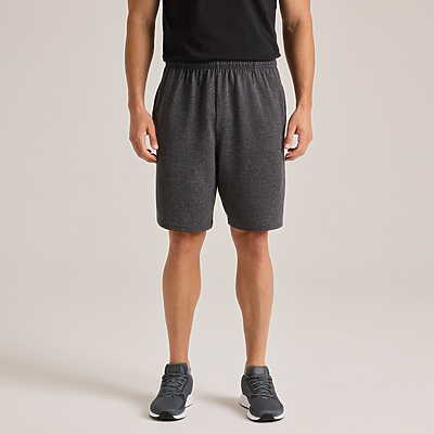 man facing front wearing black shirt and grey adult heavyweight shorts M774 back view