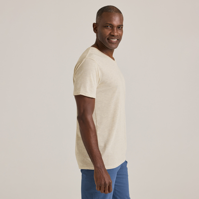 man looking to side wearing Delta Platinum Adult Tri-Blend Short Sleeve V-Neck blank wholesale Tee in oatmeal heather color