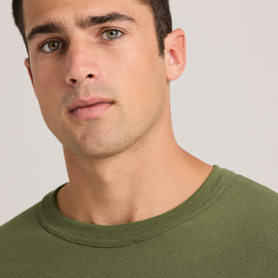 man looking forward wearing olive green adult unisex military longsleeve M290 closeup on neckline